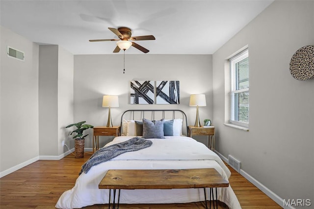 bedroom featuring wood finished floors, baseboards, and ceiling fan
