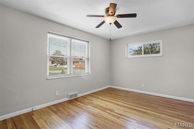empty room featuring baseboards, light wood-type flooring, and a ceiling fan