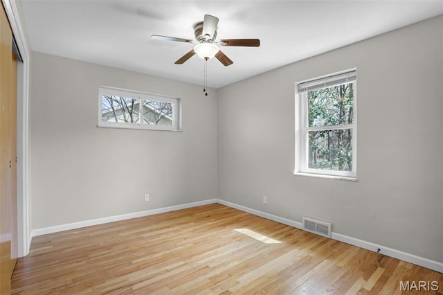 unfurnished room with baseboards, light wood-type flooring, and a ceiling fan