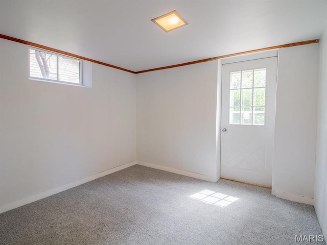 carpeted empty room with ornamental molding and baseboards