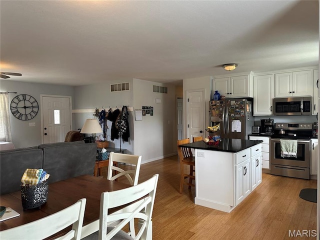404 Crystal Ln, Rosebud, MO 63091 - kitchen featuring appliances with stainless steel finishes, open floor plan, light wood-style floors, and dark countertops