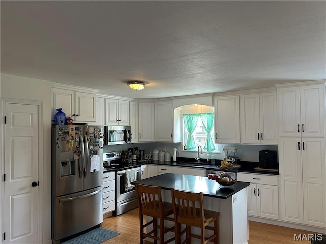 404 Crystal Ln, Rosebud, MO 63091 - kitchen with stainless steel appliances, a sink, dark countertops, and light wood-style floors