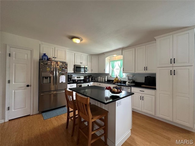 404 Crystal Ln, Rosebud, MO 63091 - kitchen with appliances with stainless steel finishes, light wood-style floors, dark countertops, and white cabinetry