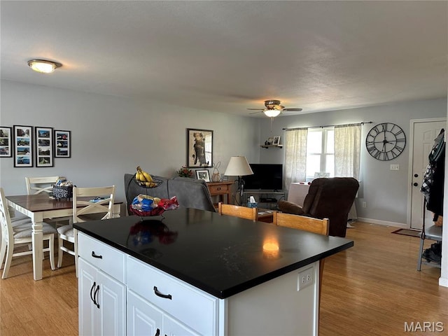 404 Crystal Ln, Rosebud, MO 63091 - kitchen featuring dark countertops, a ceiling fan, light wood finished floors, and white cabinetry