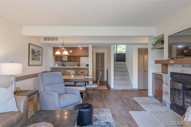 31 N Lionshead Dr, Innsbrook, MO 63390 - living area featuring stairs, dark wood finished floors, a stone fireplace, and baseboards