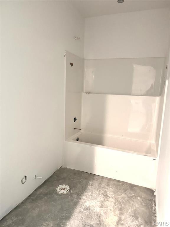 bathroom with concrete floors and shower / tub combination