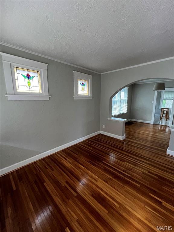 2326 Patton Ave, Saint Louis, MO 63144 - unfurnished room featuring arched walkways, hardwood / wood-style floors, baseboards, crown molding, and a textured ceiling