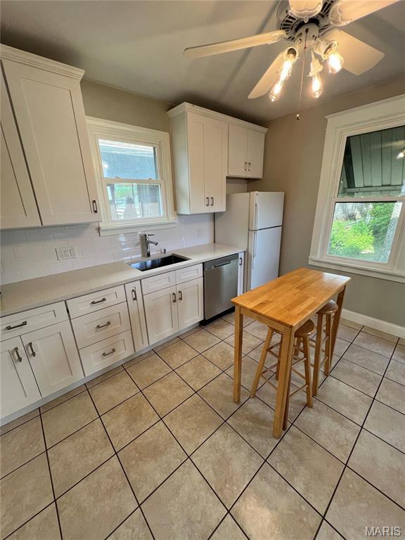 2326 Patton Ave, Saint Louis, MO 63144 - kitchen featuring dishwasher, a sink, healthy amount of natural light, and light tile patterned flooring