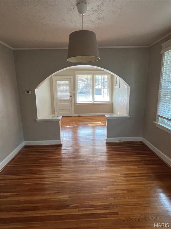 2326 Patton Ave, Saint Louis, MO 63144 - unfurnished dining area with arched walkways, wood finished floors, healthy amount of natural light, crown molding, and baseboards