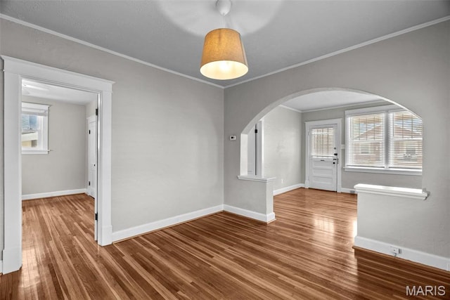 2326 Patton Ave, Saint Louis, MO 63144 - unfurnished dining area with arched walkways, wood finished floors, baseboards, and ornamental molding