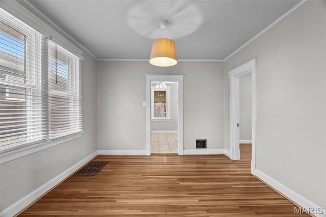2326 Patton Ave, Saint Louis, MO 63144 - unfurnished dining area with plenty of natural light, crown molding, wood finished floors, and baseboards