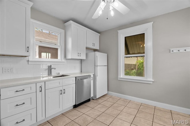 2326 Patton Ave, Saint Louis, MO 63144 - kitchen featuring stainless steel dishwasher, a sink, freestanding refrigerator, tasteful backsplash, and light countertops