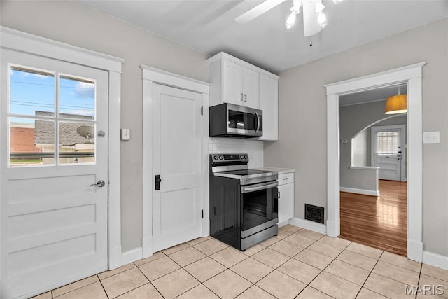 2326 Patton Ave, Saint Louis, MO 63144 - kitchen featuring stainless steel appliances, baseboards, white cabinetry, arched walkways, and a ceiling fan
