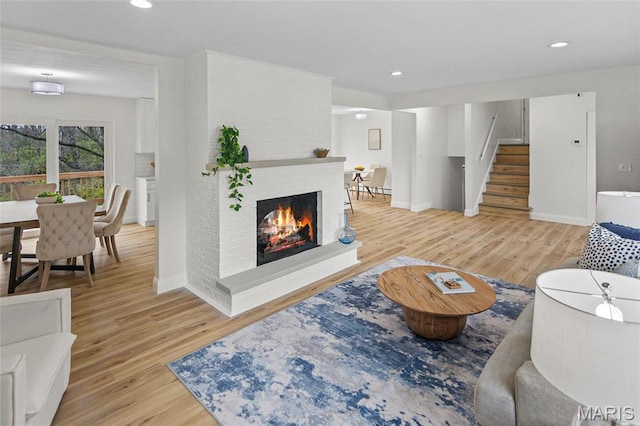 living area featuring wood finished floors, stairs, baseboards, and recessed lighting