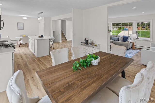 dining area with stairs, baseboard heating, light wood-style flooring, and recessed lighting