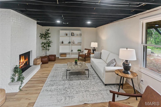 living room with wood finished floors, a fireplace, and baseboards