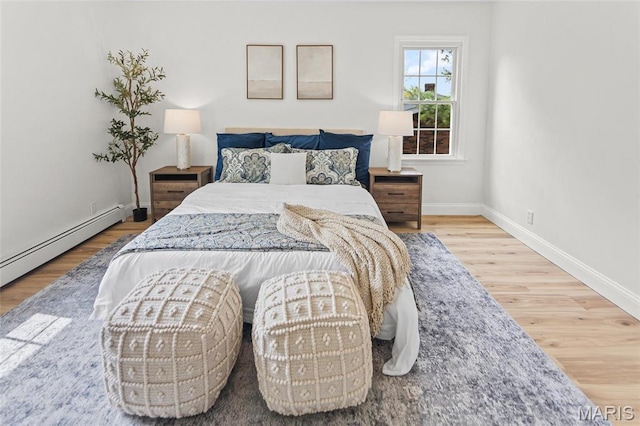 bedroom featuring wood finished floors, baseboards, and baseboard heating
