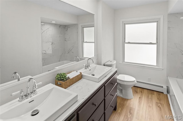 full bathroom featuring a baseboard heating unit, toilet, double vanity, and healthy amount of natural light