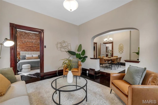 2811 Pennsylvania Ave, Saint Louis, MO 63118 - living room with arched walkways, a chandelier, wood finished floors, and baseboards