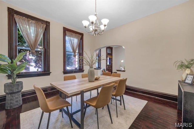 2811 Pennsylvania Ave, Saint Louis, MO 63118 - dining space featuring arched walkways, a chandelier, wood-type flooring, and baseboards
