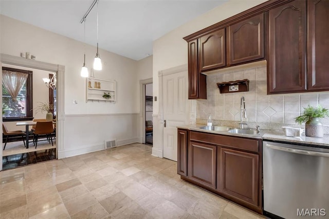 2811 Pennsylvania Ave, Saint Louis, MO 63118 - kitchen with stainless steel dishwasher, a sink, pendant lighting, dark brown cabinets, and backsplash