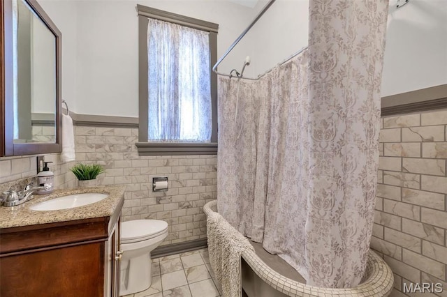 2811 Pennsylvania Ave, Saint Louis, MO 63118 - bathroom with tile walls, plenty of natural light, vanity, shower / bath combination with curtain, and toilet