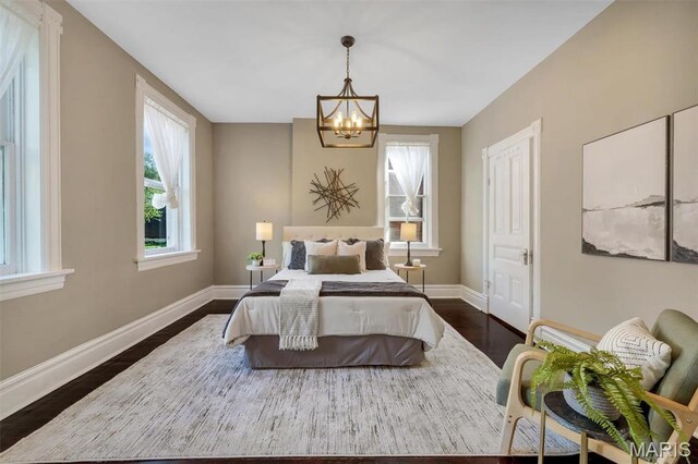 2811 Pennsylvania Ave, Saint Louis, MO 63118 - bedroom featuring a chandelier, multiple windows, dark wood-style flooring, and baseboards