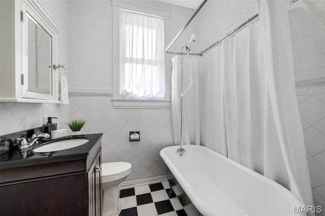 2811 Pennsylvania Ave, Saint Louis, MO 63118 - full bath featuring a freestanding tub, tile walls, tile patterned floors, vanity, and toilet