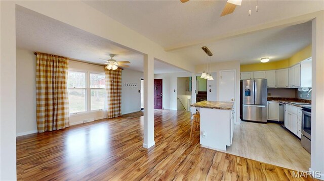 1402 Liberty Dr, Rolla, MO 65401 - kitchen with stainless steel appliances, ceiling fan, open floor plan, and light wood-type flooring