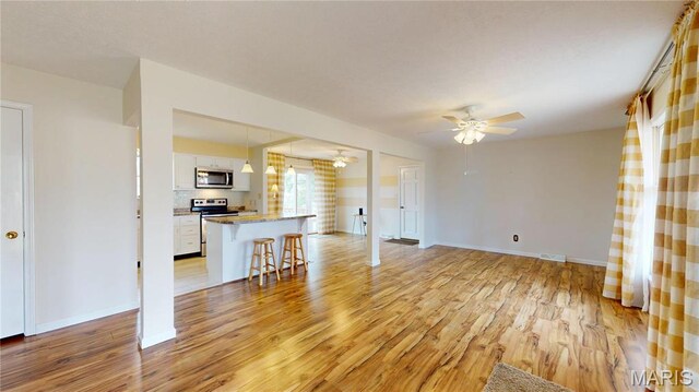 1402 Liberty Dr, Rolla, MO 65401 - unfurnished living room with ceiling fan, light wood-style flooring, and baseboards