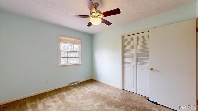 1402 Liberty Dr, Rolla, MO 65401 - unfurnished bedroom with a closet, carpet, a textured ceiling, baseboards, and ceiling fan