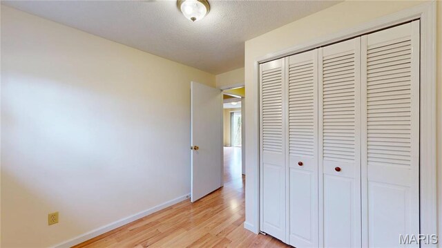 1402 Liberty Dr, Rolla, MO 65401 - unfurnished bedroom featuring a closet, light wood-style flooring, baseboards, and a textured ceiling