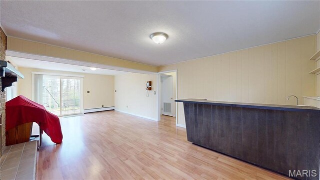 1402 Liberty Dr, Rolla, MO 65401 - unfurnished living room with baseboard heating, light wood-style floors, and baseboards