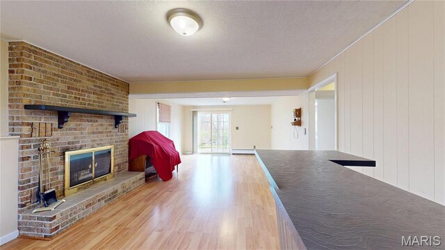 1402 Liberty Dr, Rolla, MO 65401 - unfurnished living room with a brick fireplace, wood finished floors, and baseboard heating
