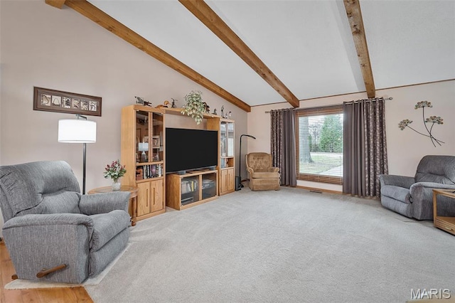 carpeted living area with beamed ceiling and high vaulted ceiling