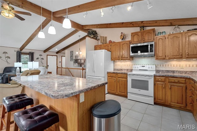 kitchen with white appliances, a kitchen island, a ceiling fan, open floor plan, and light tile patterned floors