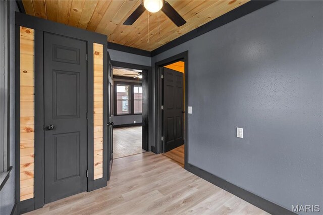 unfurnished room with a ceiling fan, baseboards, light wood-style flooring, and wood ceiling