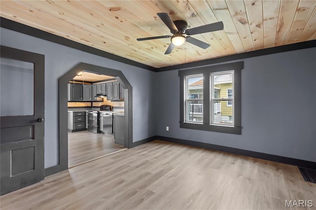 unfurnished room featuring wooden ceiling, light wood finished floors, arched walkways, ceiling fan, and baseboards