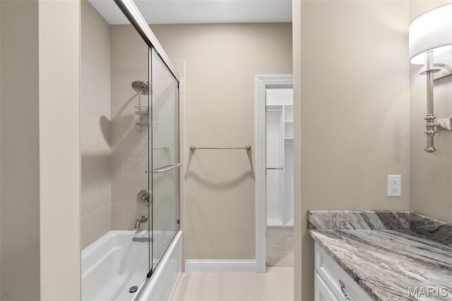 13750 Stonemont Ct, Town And Country, MO 63131 - bathroom with bath / shower combo with glass door, a walk in closet, baseboards, and vanity
