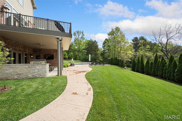 13750 Stonemont Ct, Town And Country, MO 63131 - view of grassy yard featuring exterior kitchen, a balcony, a ceiling fan, and a patio area