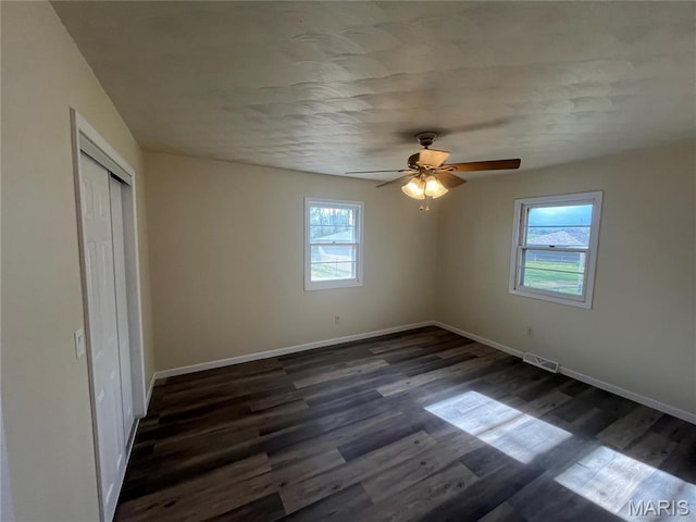 503 N Louise Ave, St James, MO 65559 - unfurnished bedroom featuring multiple windows, dark wood-style flooring, a closet, and baseboards