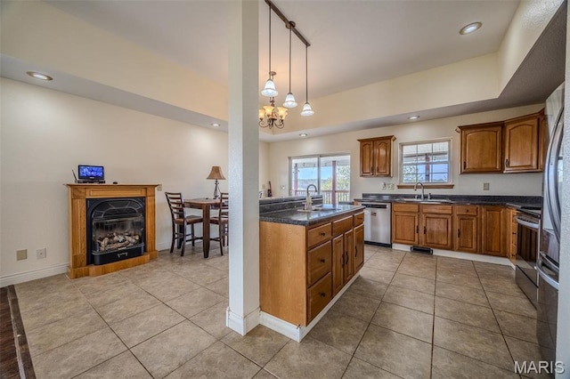20270 Hyatt Ln, Saint Robert, MO 65584 - kitchen featuring stainless steel appliances, a sink, a glass covered fireplace, and brown cabinets