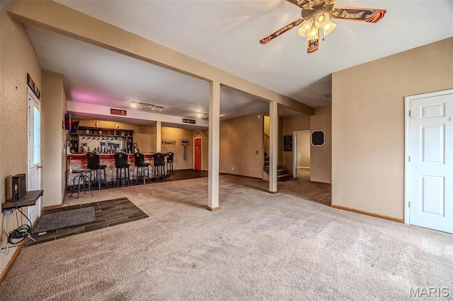 20270 Hyatt Ln, Saint Robert, MO 65584 - unfurnished living room featuring carpet flooring, a textured wall, bar, ceiling fan, and stairs