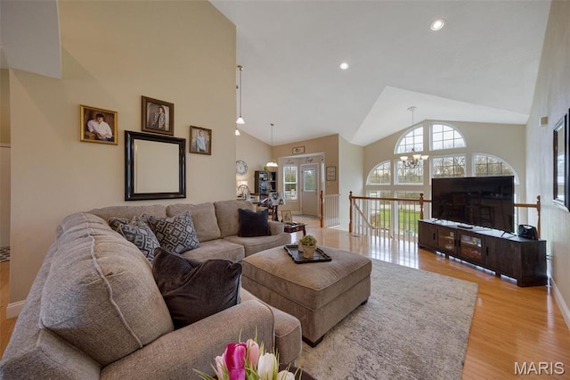 living room with baseboards, a chandelier, light wood finished floors, high vaulted ceiling, and recessed lighting