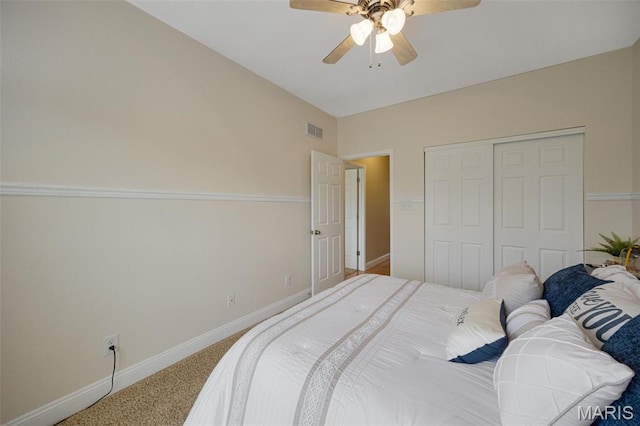 carpeted bedroom featuring a closet, baseboards, and ceiling fan