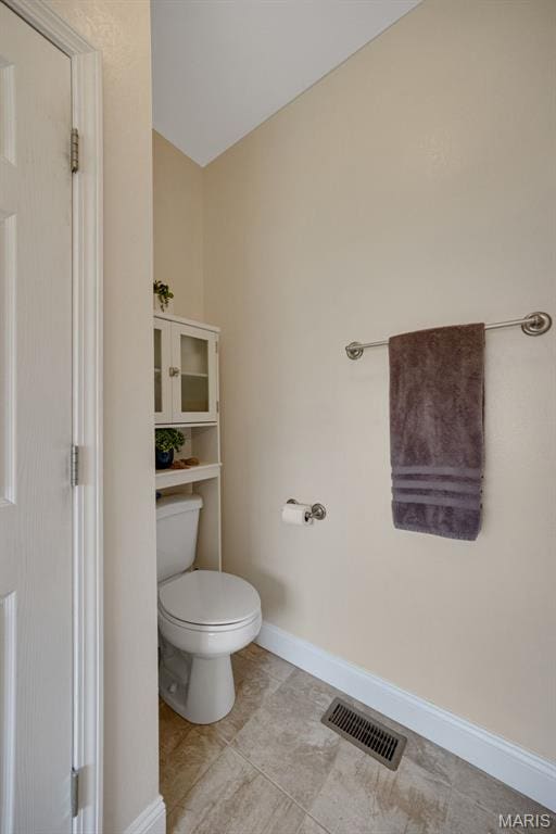 bathroom featuring toilet, baseboards, and tile patterned floors