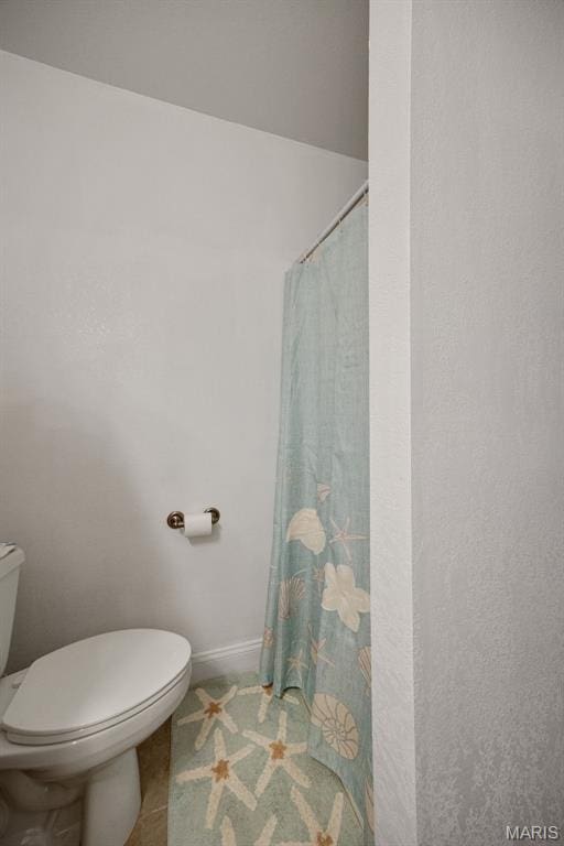 bathroom featuring toilet, tile patterned flooring, a shower with curtain, and baseboards