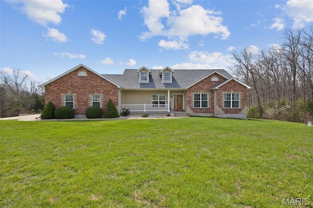 cape cod house with brick siding, covered porch, and a front lawn