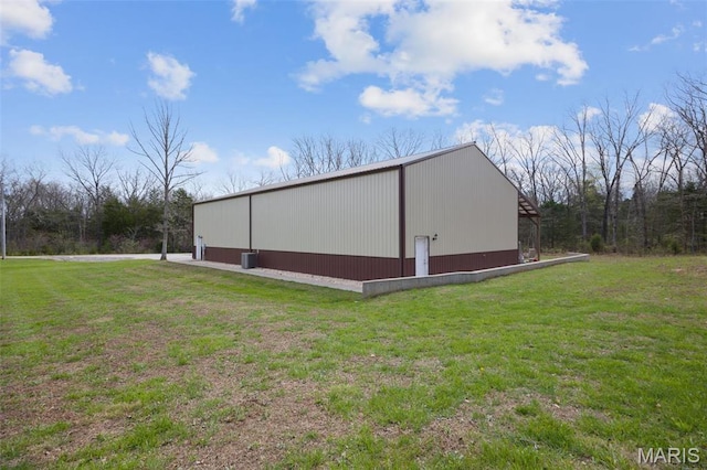 view of property exterior with a pole building, a lawn, and an outdoor structure