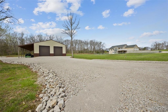view of grassy yard featuring a garage and an outbuilding